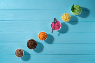 Pots of different coloured powders on a blue background 