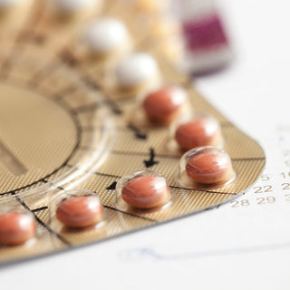 A macro image of the corner of a pill packet containing orange pills