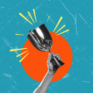 A hand holds up a silver trophy against a background featuring a large red circle and a teal blue sky with yellow lines radiating from behind the trophy, giving a sense of achievement and celebration.